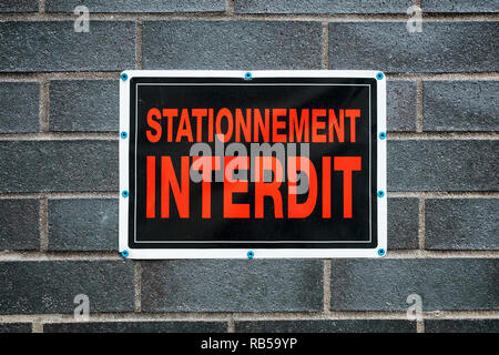 Kein Parkplatz Schild in französischer Sprache montiert auf eine graue Wand. Stationnement Interdit. Stockfoto