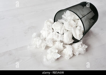 Black Metal Mülleimer voll mit zerknittertem Papier mit dem weißen Holz Diele im Büro gestürzt Stockfoto