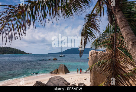 Paar stehend auf den Strand einer kleinen Insel der Seychellen am Meer und Katamaran. Stockfoto