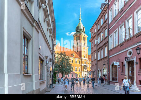 Warschau, Polen - 10. Juli 2018 - Touristen zu Fuß mit einer schönen Kirche im Hintergrund in der Altstadt von Warschau in einem späten Nachmittag Stockfoto