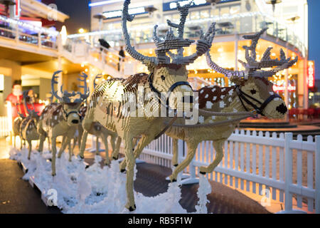 Ein Weihnachtsmann Schlitten mit 8 Rentiere aus 750.000 LEGO Steinen am Tacoma Square, Mermaid Quay, Cardiff Bay. Die Modelle dauerte 3 Monate, zu bauen und zu werden Stockfoto