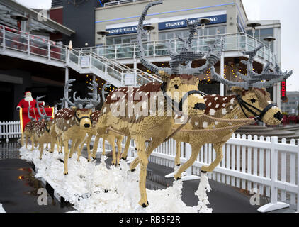 Ein Weihnachtsmann Schlitten mit 8 Rentiere aus 750.000 LEGO Steinen am Tacoma Square, Mermaid Quay, Cardiff Bay. Die Modelle dauerte 3 Monate, zu bauen und zu werden Stockfoto