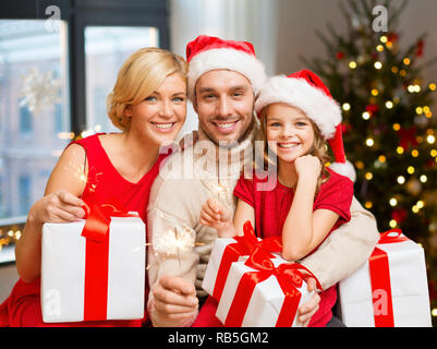 Familie mit Weihnachten Geschenke und Wunderkerzen zu Hause Stockfoto