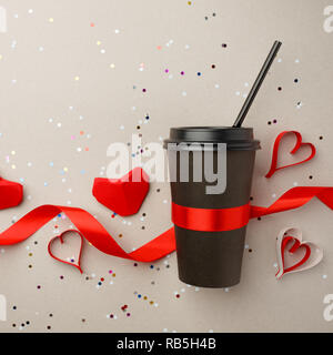 Kreatives Konzept Foto, schwarz stilvolle nehmen Kaffeetasse mit origami Papier roten Herzen auf grauem Hintergrund. Aber erste Kaffee Liebe und Valentinstag da Stockfoto