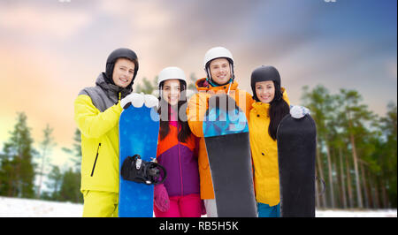 Glückliche Freunde in Helme mit Snowboards im freien Stockfoto