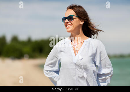 Glücklich lächelnde Frau mit Sonnenbrille auf Sommer Strand Stockfoto