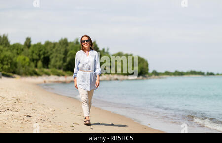 Glücklich lächelnde Frau entlang Sommer Strand Stockfoto