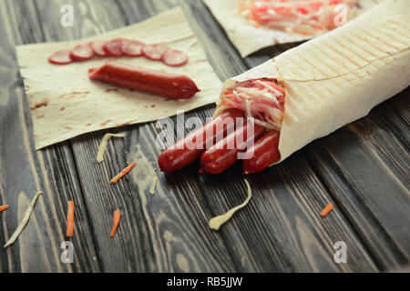 Geräucherte Wurst in pita Brot auf hölzernen Hintergrund Stockfoto