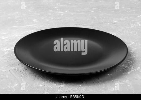 Blick von oben auf die Matte runde Leere schwarze Platte auf grauem Zement Hintergrund Kopie Platz für Sie entwerfen. Perspektive betrachten. Stockfoto
