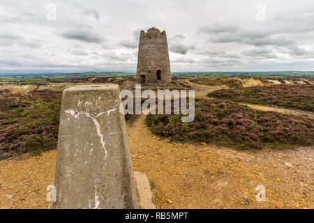 Verfallene Mühle und trig Point, Parys Mountain, Amlwch, Anglesey, Wales, Vereinigtes Königreich. Stockfoto