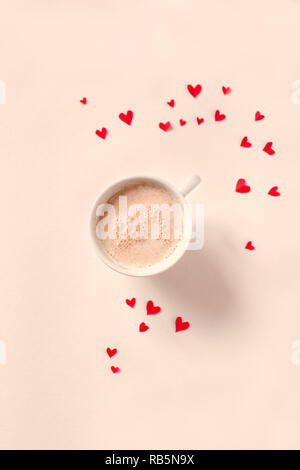 Tasse Kaffee und roten Herzen auf beigem Hintergrund, kopieren. Minimale flach mit Cappuccino Kaffee für Valentinstag, Liebe und Romanze conc Stockfoto