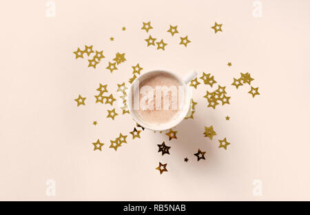 Tasse Kaffee und goldenen Sternen auf beige Pastell Hintergrund, kopieren. Minimale flach mit Cappuccino Kaffee und Sterne, Ansicht von oben. Stockfoto