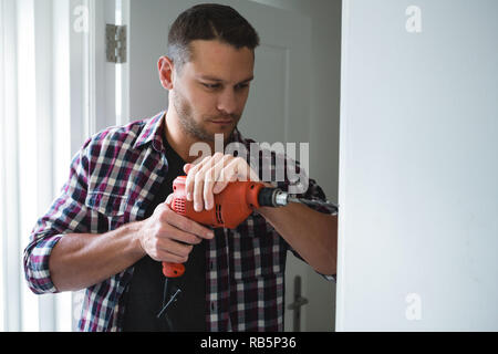 Männliche Tischler mit der Bohrmaschine Maschine Stockfoto