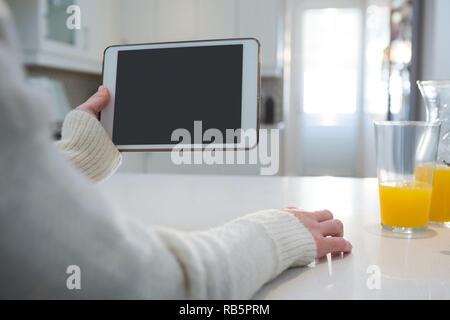 Frau mit digitalen Tablet in der Küche zu Hause. Stockfoto