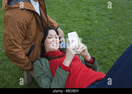 Frau mit Mobiltelefon mit Mann Stockfoto