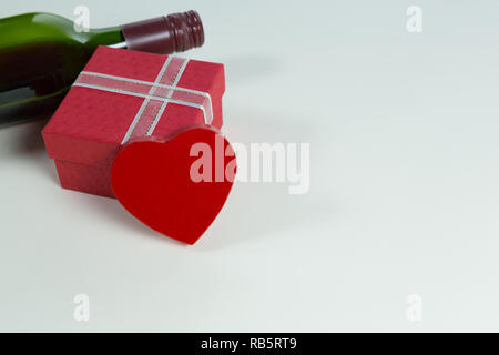 Weinflasche mit Valentine Geschenk und Dekoration auf weißem Hintergrund Stockfoto