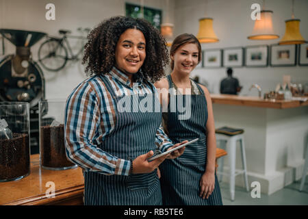 Portrait der Unternehmer einer Kaffeerösterei und Cafe. Mischlinge Kerl mit einem Tablet-PC Stockfoto