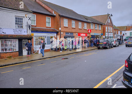 Eine lange Schlange von Menschen auf dem Bürgersteig warten die örtlichen Metzgern Shop in der Nähe von Weihnachten in Thatcham High Street, Berkshire, Großbritannien Stockfoto