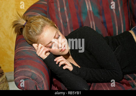 Blonde Mädchen in ein Nickerchen auf dem Sofa Stockfoto