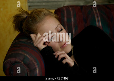 Blonde Mädchen in ein Nickerchen auf dem Sofa Stockfoto