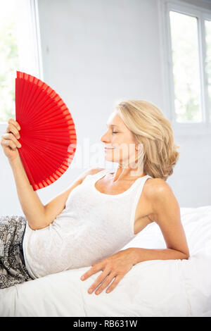 Frau Abkühlung mit einem Ventilator. Stockfoto