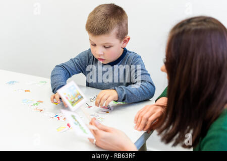 Junge in Logopädie Büro. Preschooler trainieren die richtige Aussprache mit der logopädin. Kind Ergotherapie Sitzung. Stockfoto