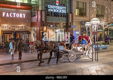 Denver, Colorado - eine Pferdekutsche Passagiere auf der 16th Street Fußgängerzone während der Weihnachtszeit. Stockfoto