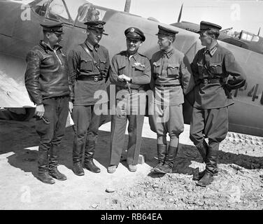 Foto von Major General Lewis Brererton in der Mitte, der Oberbefehlshaber der US-Armee in den Nahen Osten mit einer Gruppe russischer Offiziere vor einem amerikanischen Kampfflugzeugs an die Russen ausgeliefert. Ein United States kampfflugzeugs wird im Hintergrund geprüft und trägt das Red Star insignia Russlands, das durch Ausfüllen der White Star der Vereinigten Staaten mit roter Farbe. Von Nick parrino fotografiert. Vom 1943 Stockfoto