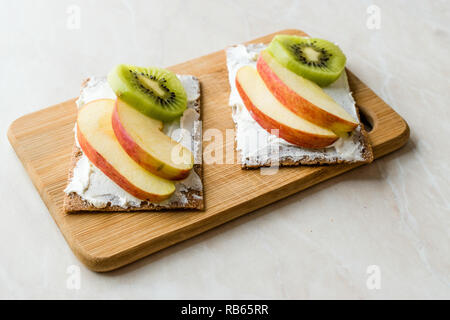 Roggen Cripsbread mit Frischkäse, Apfelscheiben und Kiwi/gesunde Snacks Rezept mit Bio-lebensmitteln. Stockfoto