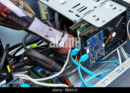 Reinigen der Kabel, die auf der Festplatte des PC angeschlossen sind. Stockfoto