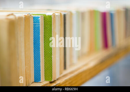 Reihe der alten bunten Bücher auf einem Holzregal in einem Book Store Stockfoto