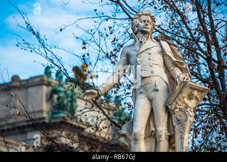 Mozart Statue an Neue Burg Gebäude Teil der Hofburg Palace Complex von Burggarten gesehen. Wien, Österreich. Stockfoto