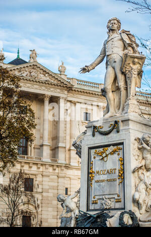 Mozart Statue an Neue Burg Gebäude Teil der Hofburg Palace Complex von Burggarten gesehen. Wien, Österreich. Stockfoto