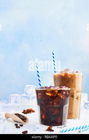 Sommer trinken Eiskaffee oder Soda in einem Glas Kaffee mit Sahne und Eis in ein hohes Glas mit Eiswürfel, Kaffeebohnen und verschiedenen Gewürzen auf Schnee umgeben Stockfoto