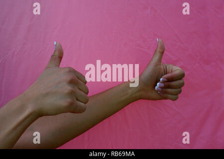 Brünette Frau zwei Daumen hoch mit einem rosa Hintergrund Stockfoto