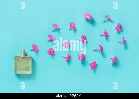 Kreative noch leben. Parfüm und blühenden Blumen rosa auf Blau. Konzept verbreitete sich der Duft. Ansicht von oben Stockfoto