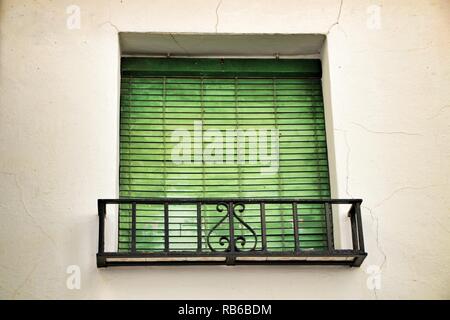 Altes haus Fassade mit rostigen Balkon und Grün blind in Cordoba, Spanien. Stockfoto