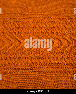 Orange Braun Terracotta Strickmuster Wollpullover Textur hautnah. Handgemachte orange braun Stricken wolle Textur Hintergrund Stockfoto