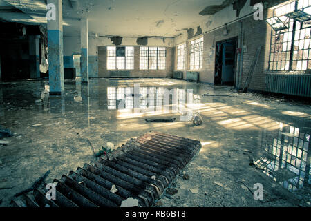 Innenraum der verlassenen Nervenheilanstalt mit kaputten Fenstern und Wasser Hochwasser auf dem Boden Stockfoto