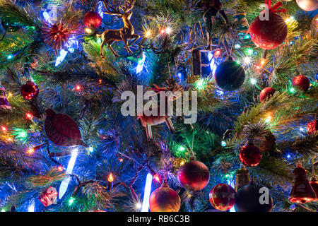 Eine Nahaufnahme von Dekorationen und Lichterketten am Weihnachtsbaum in England Stockfoto