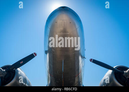 Der Blick unter die Nase von einem Jahrgang zwei prop Passagierflugzeugs gegen die Sonne und blauer Himmel Stockfoto