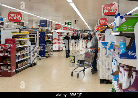 Käufer in der Mittelgang in einem großen Sainsbury's Supermarkt in Großbritannien Stockfoto