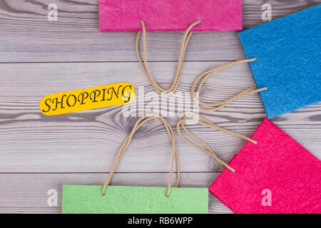 Knautschzone Kraftpapier farbig Geschenkbeutel. Set aus bunten Tragetaschen und gelbe Karte mit Beschriftung einkaufen. Papier shopper Mode. Stockfoto