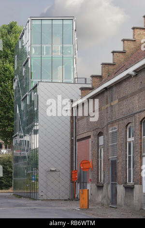 Die Außenseite des studio Gebäude mit Glas und Fliesen- Fassaden gegen Laub. Les Ballets C de la B, Gent, Belgien. Architekt: Architecten Stockfoto