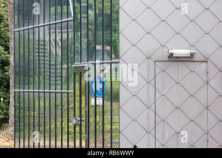 Die Außenseite des studio Gebäude mit Glas und Fliesen- Fassaden gegen Laub. Les Ballets C de la B, Gent, Belgien. Architekt: Architecten Stockfoto