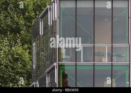 Die Außenseite des studio Gebäude mit Glas und Fliesen- Fassaden gegen Laub. Les Ballets C de la B, Gent, Belgien. Architekt: Architecten Stockfoto