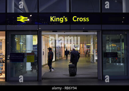 Glas, Fenster, Türen und der Eingang zum Bahnhof King's Cross, London, England, in der Nacht. Stockfoto