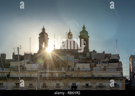 Kirche Unserer Lieben Frau vom Sieg, Senglea, Malta mit Gebäuden und Objektivreflexionen. Stockfoto