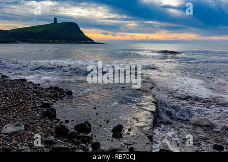 Landschaft Foto auf kimmeridge Bay Beach aus der Waschmaschine Leiste auf Clavell Tower unter dramatischen Himmel suchen. Stockfoto