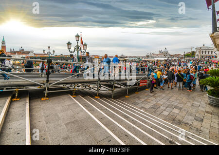 Touristen Masse die Marktstände und Cafés an einem ereignisreichen Tag an der Uferpromenade Riva degli Schiavoni Promenade entlang des Grand Canal in der Nähe des Markusplatzes Stockfoto